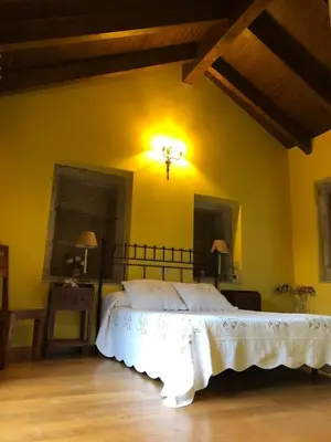 a bedroom with a bed in a yellow wall at Casa Rural Anxeliña in Boborás