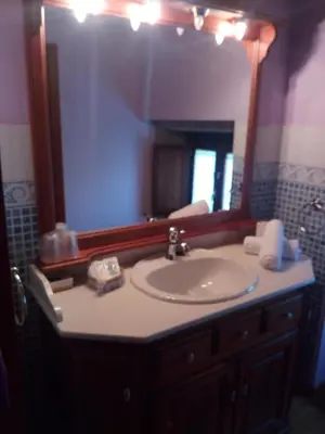 a bathroom with a sink and a large mirror at Casa Rural Anxeliña in Boborás
