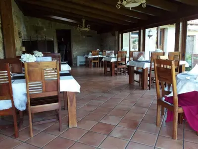 a dining room with tables and chairs in a building at Casa Rural Anxeliña in Boborás