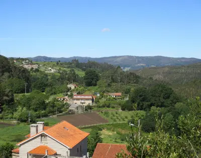 a small village on a hill with houses and trees at Hotel Chola in Dorna