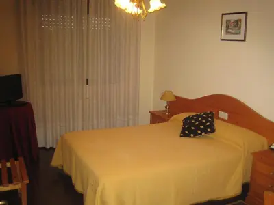 a bedroom with a bed with a yellow bedspread at Hotel Chola in Dorna