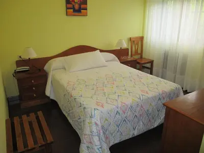 a bedroom with a bed and a dresser with two lamps at Hotel Chola in Dorna