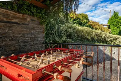 a wooden foosball table sitting next to a fence at Alborada del Eo in Vegadeo