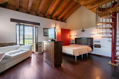 a bedroom with a bed and a couch in a room at Alborada del Eo in Vegadeo