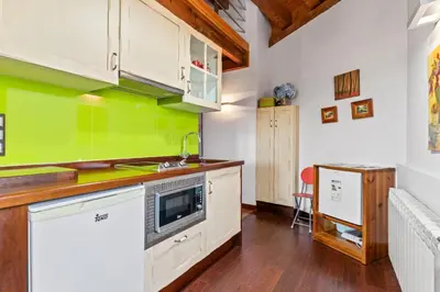 a kitchen with white cabinets and green walls at Alborada del Eo in Vegadeo