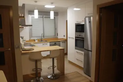 a kitchen with a table and a refrigerator at Rosalía de Castro, 41 - Centro - VUT-CO-01904 in Santiago de Compostela