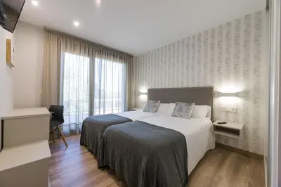 a hotel room with a large bed and a window at Hotel A Curuxa Wellness in Arzúa