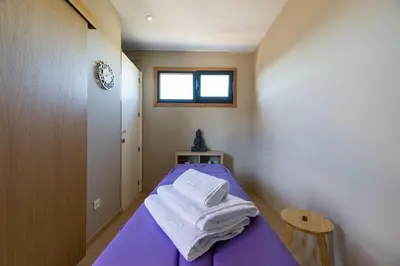 a room with a purple bed with towels on it at Hotel A Curuxa Wellness in Arzúa
