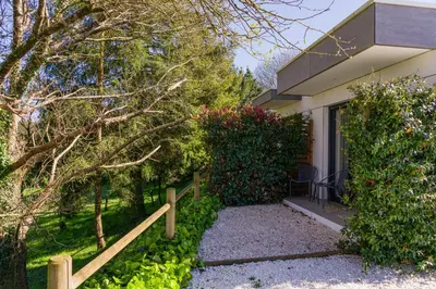 a house with a fence and some bushes at Hotel A Curuxa Wellness in Arzúa