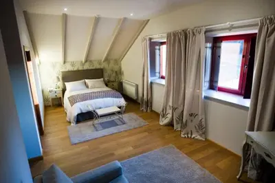 a bedroom with a bed and two windows at Casa das Veigas in Santa Eulalia