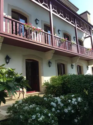 a building with a balcony with flowers on it at Casa das Veigas in Santa Eulalia