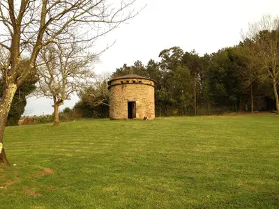an old brick tower in a field of grass at Casa das Veigas in Santa Eulalia