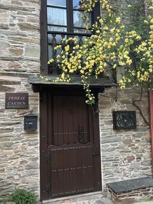 a building with a wooden door with yellow flowers at Pereje Garden in Pereje