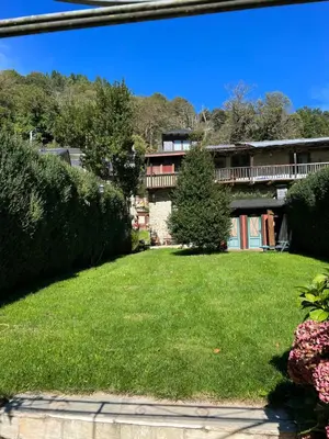 a house with a green yard with bushes at Pereje Garden in Pereje
