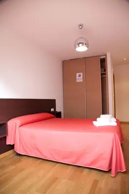 a bedroom with a red bed and a closet at Hostal CASASNOVAS in Silleda