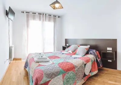 a bedroom with a bed with a colorful quilt at Hostal CASASNOVAS in Silleda