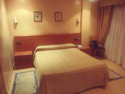 a hotel room with a bed and a chair at Hotel orly in Xinzo de Limia