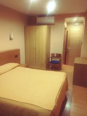 a hotel room with a bed and a chair at Hotel orly in Xinzo de Limia