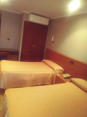 a hotel room with two beds and a red door at Hotel orly in Xinzo de Limia