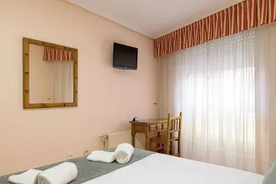 a bedroom with a bed and a mirror and a television at Hotel Alda Xinzo in Xinzo de Limia
