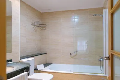 a bathroom with a tub and a toilet and a sink at Hotel Alda Xinzo in Xinzo de Limia