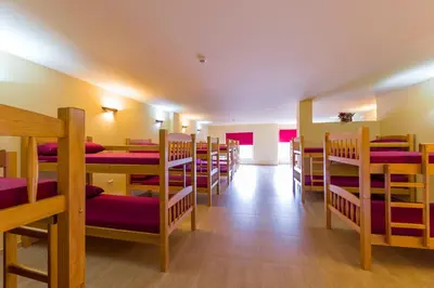 a room with rows of tables and chairs at Albergue Vía Láctea in Arzúa