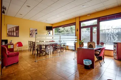 a living room with a table and chairs at Albergue Vía Láctea in Arzúa