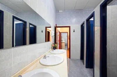 two sinks in a bathroom with two mirrors at Albergue Vía Láctea in Arzúa