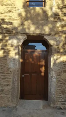 a wooden garage door in a stone building at O Trancallo in Viana do Bolo