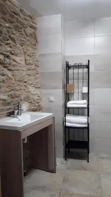 a bathroom with a sink and a shelf with towels at O Trancallo in Viana do Bolo