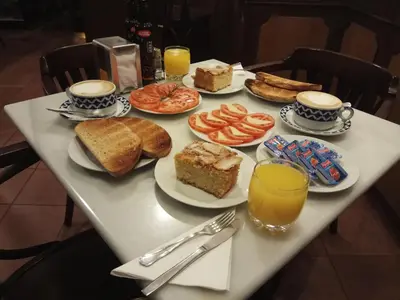 a table topped with plates of food and orange juice at Hotel Casa de Caldelas in Castro Caldelas