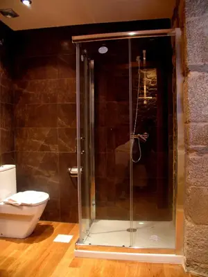 a glass shower in a bathroom with a toilet at Hotel Casa de Caldelas in Castro Caldelas