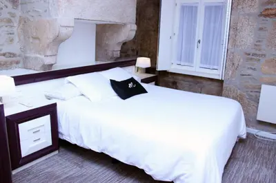 a bedroom with a white bed and a window at Hotel Montenegro Compostela in Santiago de Compostela