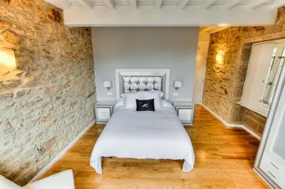 a bedroom with a bed and a stone wall at Hotel Montenegro Compostela in Santiago de Compostela