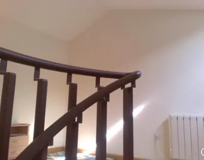 a staircase with a black railing in a room at A Coruña al lado de la playa in Bastiagueiro