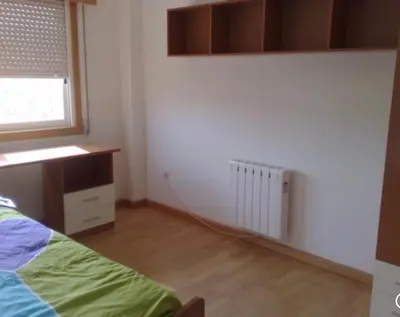 a bedroom with a bed and a window and a radiator at A Coruña al lado de la playa in Bastiagueiro