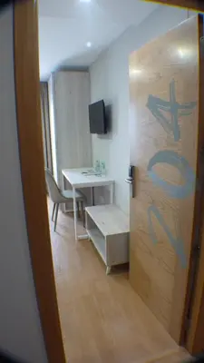 a door to a room with a desk and a table at Hotel Roquiño in Caldas de Reis
