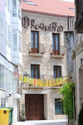 a building with a bunch of colorful flags on it at Hotel Roquiño in Caldas de Reis