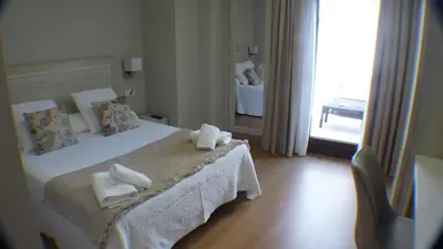 a hotel room with a bed with towels on it at Hotel Roquiño in Caldas de Reis