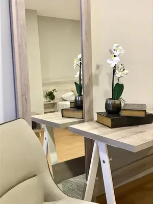 a mirror on a table with flowers and a chair at Hotel Roquiño in Caldas de Reis
