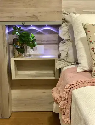 a bed with a night stand with a plant on it at Hotel Roquiño in Caldas de Reis