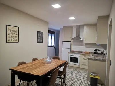 a kitchen with a wooden table and chairs in it at Hotel Arco Navia in Navia