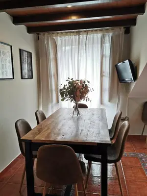 a dining room table with chairs and a vase of flowers at Hotel Arco Navia in Navia