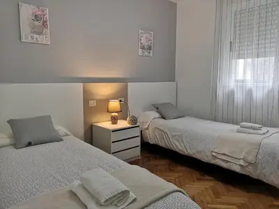 a bedroom with two beds and a table with a lamp at Ático Camino De Santiago 2 in Sarria