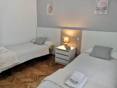 a room with two beds and a table with a lamp at Ático Camino De Santiago 2 in Sarria