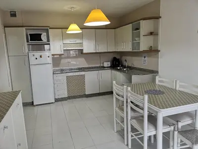 a kitchen with a table and a white refrigerator at Ático Camino De Santiago 2 in Sarria