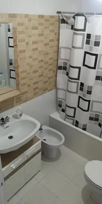 a bathroom with a sink and a toilet and a mirror at Ático Camino De Santiago 2 in Sarria