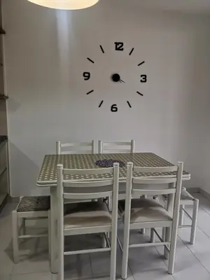 a table and chairs with a clock on a wall at Ático Camino De Santiago 2 in Sarria