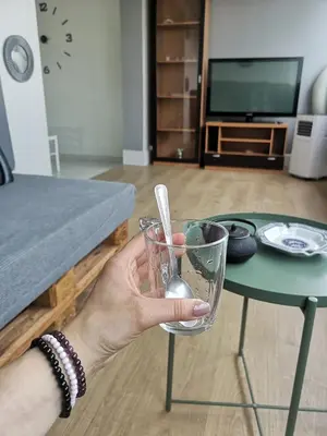 a person holding a glass in front of a table at Ático Camino De Santiago 2 in Sarria