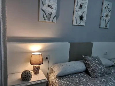 a bedroom with a bed and a lamp on a night stand at Ático Camino De Santiago 2 in Sarria
